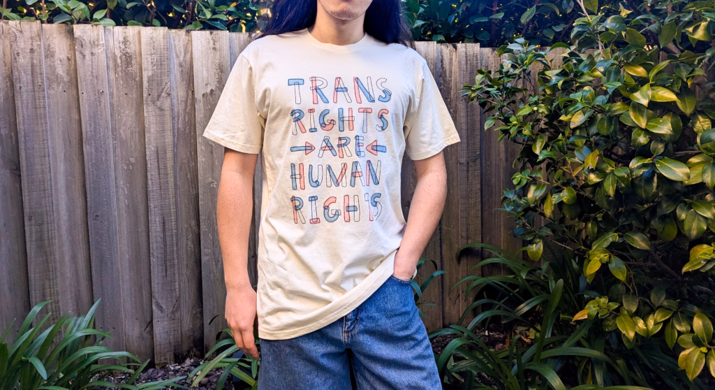 The attached photo illustrates everyday trans solidarity; it’s Claire’s artwork, separate from Jaimie’s fundraiser artwork.